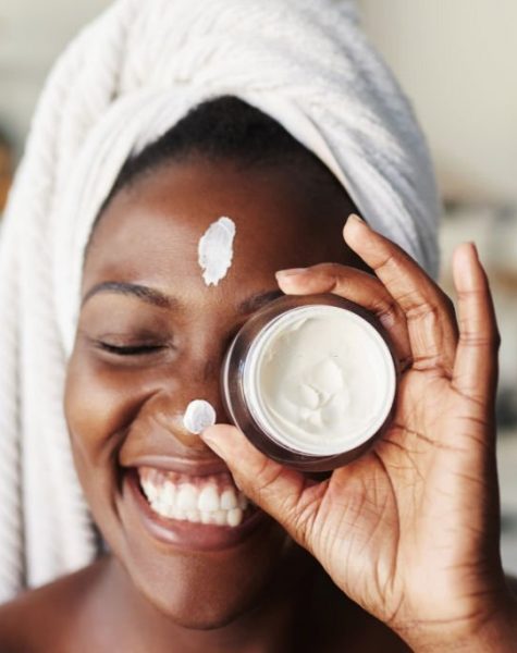 Shot of a beautiful young woman holding up a face cream product